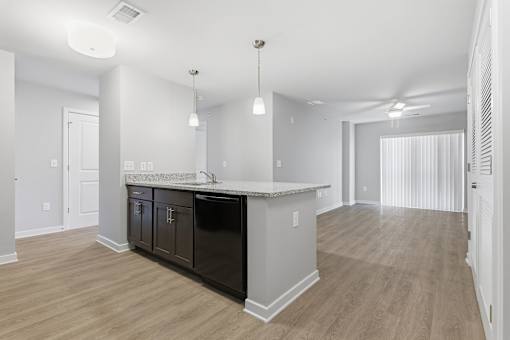 A kitchen with a black dishwasher and a white countertop.