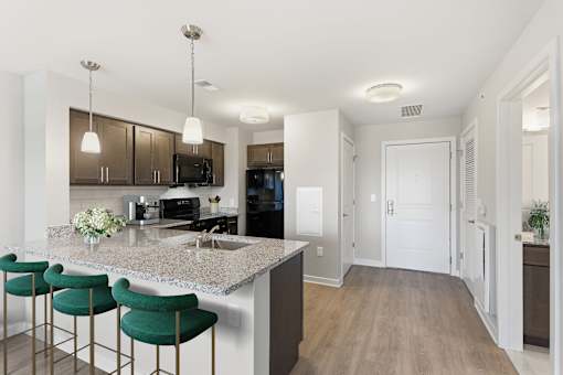 A kitchen with a bar area and green bar stools.