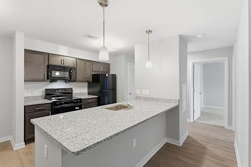 A kitchen with a granite countertop and stainless steel appliances.