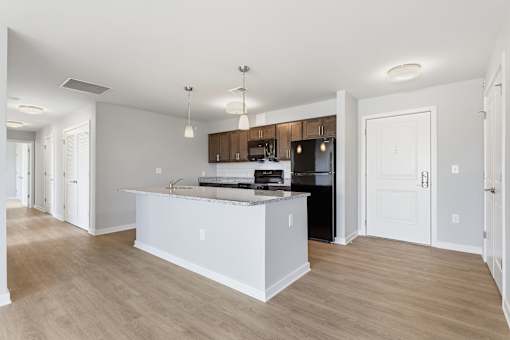 A kitchen with a white island and wooden floors.