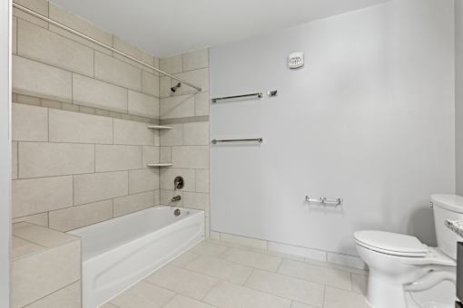 A white bathroom with a tub, toilet, and sink.