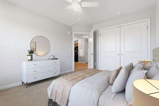 A bedroom with a bed, dresser, and mirror.