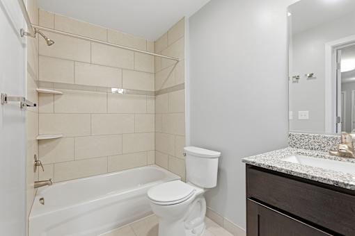 A white toilet sits next to a bathtub in a bathroom.