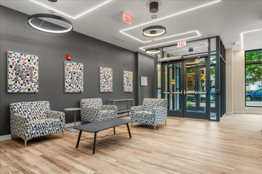 a lobby with chairs and a table and a glass door