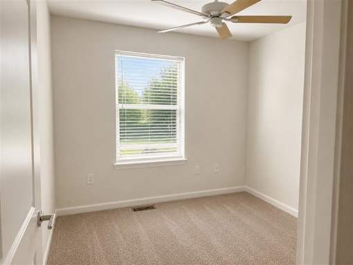 A room with a window and a ceiling fan.