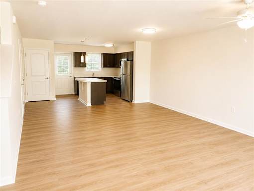 A kitchen with a refrigerator, sink, and cabinets.