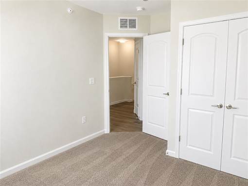 A room with a carpeted floor and a white door.