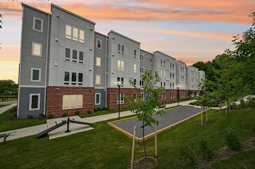 Apartment complex with a walkway in front.