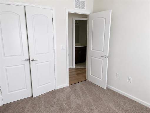 A white door is open to a dark room.