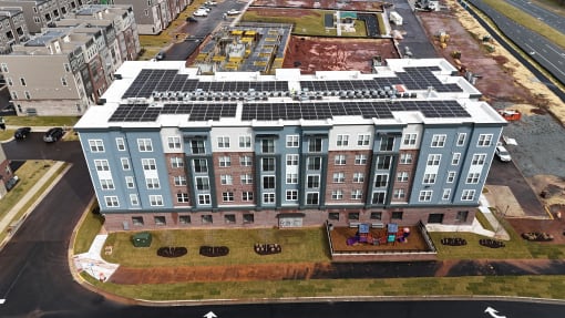 an aerial view of an apartment building with solar panels on the roof