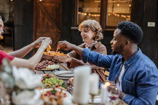 A group of people are gathered around a table, enjoying a meal together.