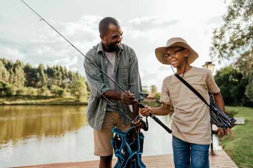 A man and a boy are fishing by a lake.