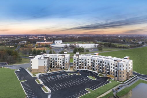 an aerial view of a large building with a parking lot in front of it