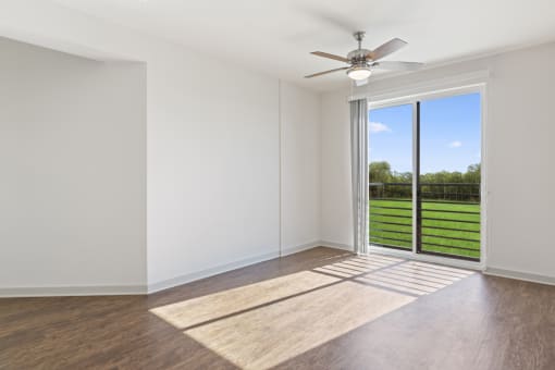 an empty living room with a sliding glass door and a view of the backyard
