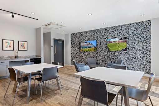 A modern dining room with a large table and chairs.