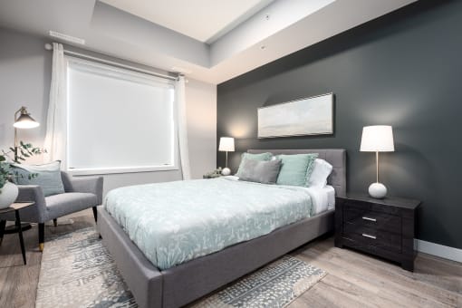 a bedroom with a bed and a chair and a window