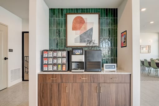 a room with a desk with a computer on it and a painting on the wall