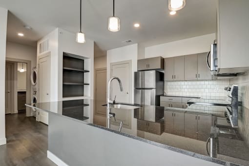 a kitchen with a large center island with a sink and a chrome faucet