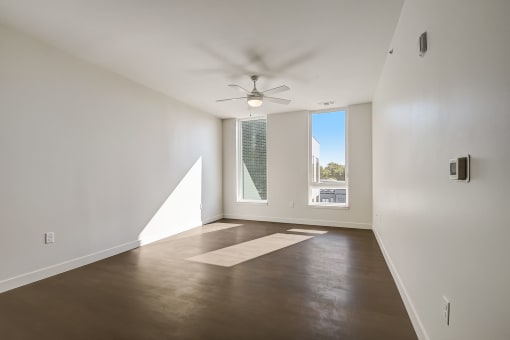 a living room with white walls and a large window
