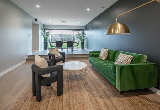 a living room with a green couch and two chairs