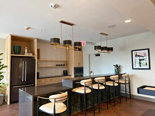 A modern kitchen with a bar area and a fridge on the left.