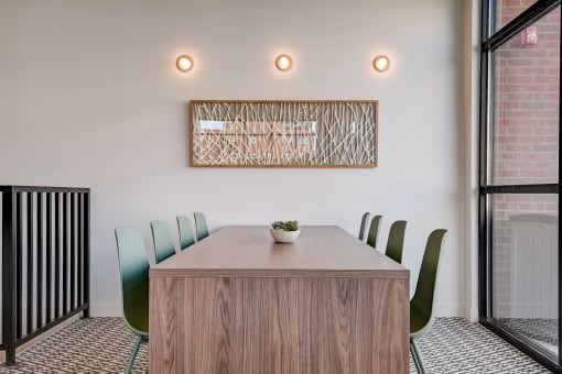 a meeting room with a wooden table and green chairs