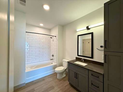 A bathroom with a white tub, sink, and toilet.