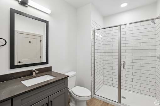 A bathroom with a toilet, sink, and shower.
