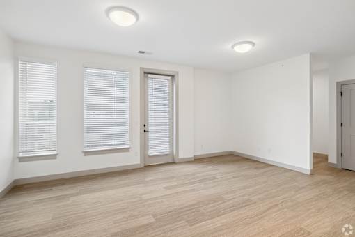 A room with wooden flooring and white walls.