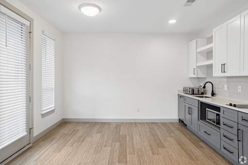A kitchen with white cabinets and a microwave.