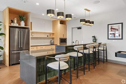 A modern kitchen with a bar area and stools.