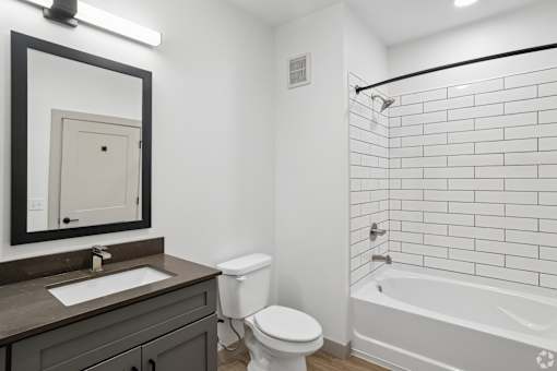 A bathroom with a white toilet, a sink, and a bathtub.