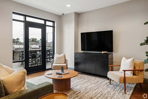 A living room with a flat screen TV, a chair, a sofa, and a coffee table.