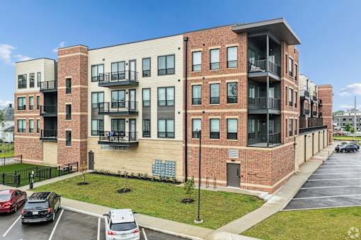A multi-story apartment building with a parking lot in front.