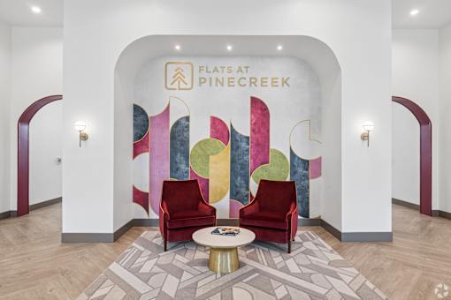 A lobby with a white wall and a painting of a tree.