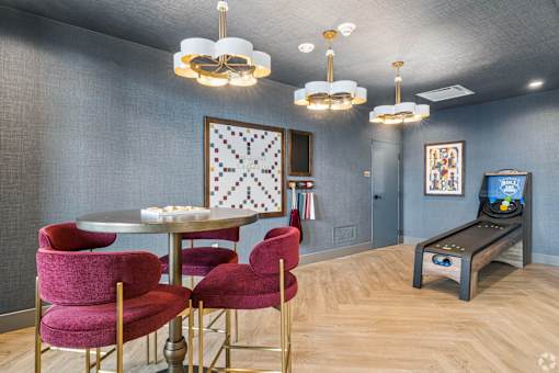 A room with a round table and chairs with a TV in the corner.