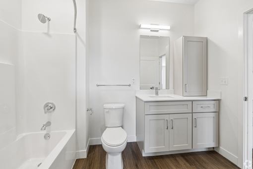 A white bathroom with a toilet, sink, and bathtub.