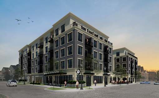 A modern apartment building with a parking lot in front.