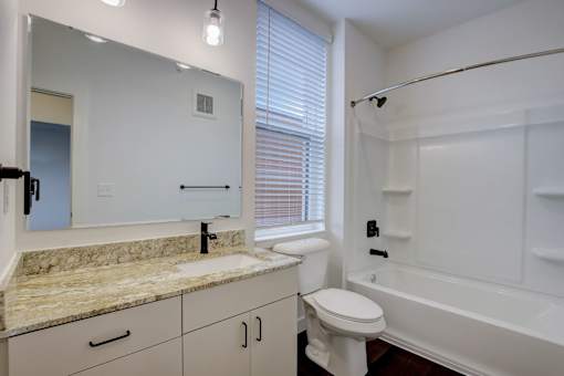 A bathroom with a sink, toilet, and bathtub.