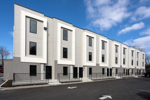 a row of white apartment buildings with a street in front of them