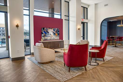 A large room with red chairs and a painting on the wall.