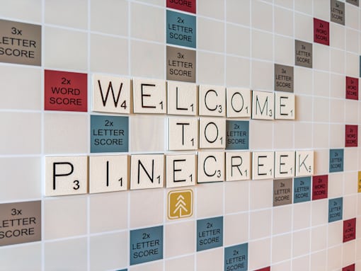 A wall with tiles spelling out the words "Welcome to Pine Creek".