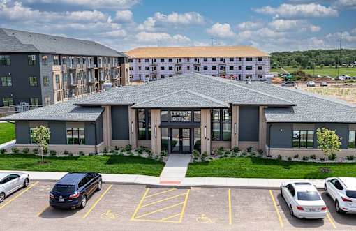 A parking lot in front of a building with a sign that says "OFFICE".