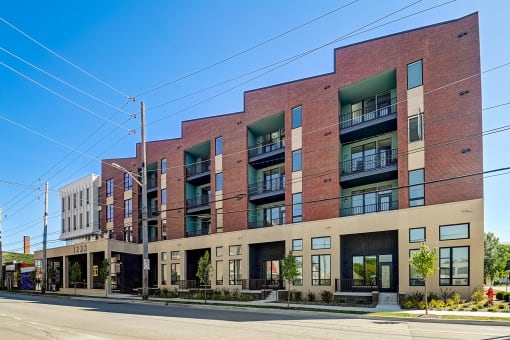 a large brick building with many windows and a street in front of it
