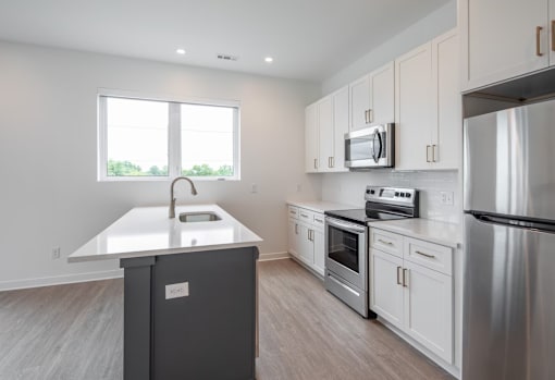 A kitchen with a stainless steel refrigerator, oven, and microwave.