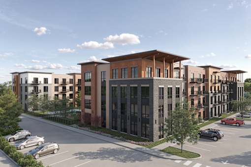 A modern apartment complex with a parking lot in front.