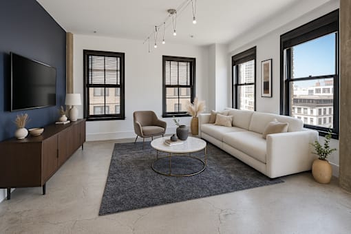 A living room with a white couch, a brown cabinet, and a television.