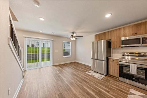 A kitchen with a refrigerator, oven, and microwave.