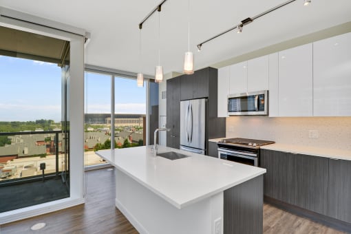 an open kitchen with a large white island and a large window
