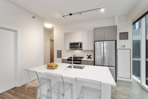 a kitchen with a white counter top and a stainless steel refrigerator